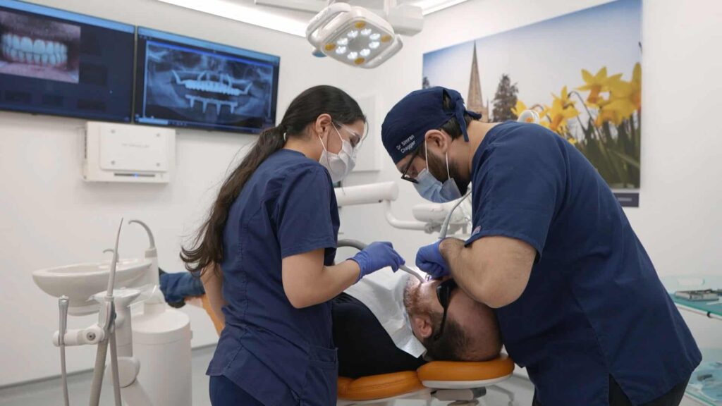 dental implant doctor and nurse helping patient at checkup