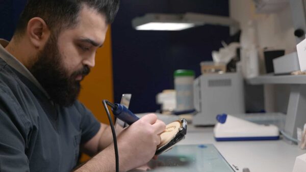 dental technician works on smile in a day prosthetic