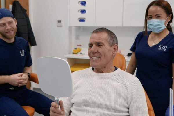 evodental smiling patient holding mirror